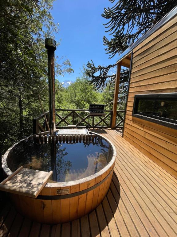 una bañera de hidromasaje en una terraza de madera en BordeArroyo Malalcahuello, en Malalcahuello