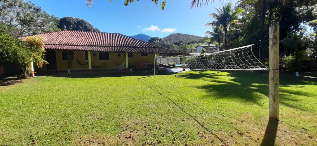 a house with a hammock in front of a yard at Casa do Maurição Refúgio da Família in Casimiro de Abreu