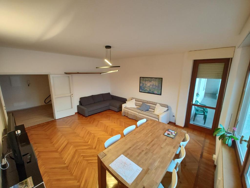 - un salon avec une table en bois et un canapé dans l'établissement Casa Battisti, à Sondrio