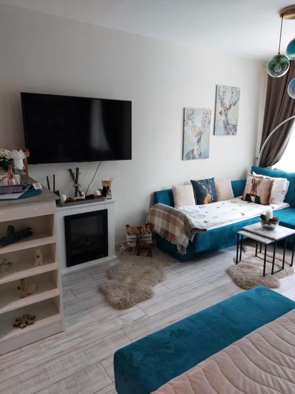 een woonkamer met een bank en een flatscreen-tv bij MAGRI Luxurious Apartment A42 Borovets Gardens in Borovets