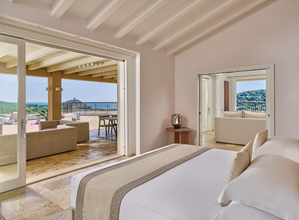 a bedroom with a bed and a view of the ocean at Conrad Chia Laguna Sardinia in Chia