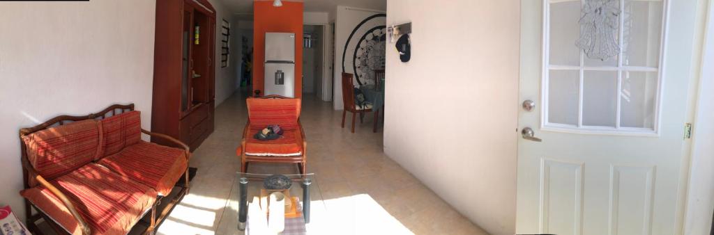 a hallway with two chairs and a table and a door at Depto Duplex Cancún (Cuarto) in Cancún