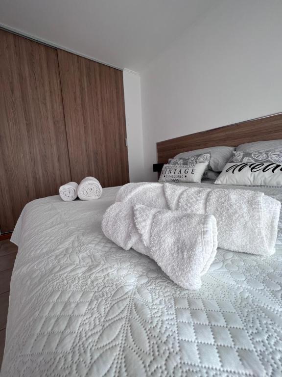 Una cama blanca con dos toallas blancas. en Luxury Spinetto en Santa Rosa