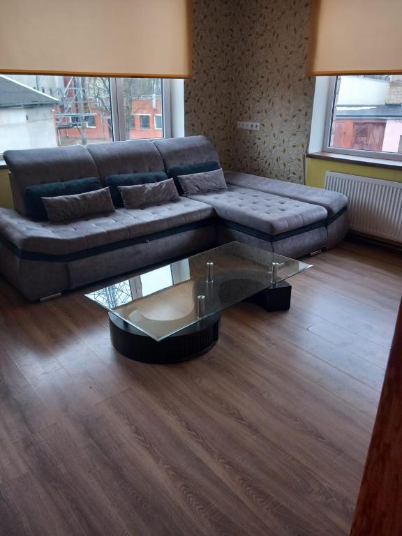 uma sala de estar com um sofá e uma mesa de café em vidro em Balvu centrs Partizanu 10 em Balvi