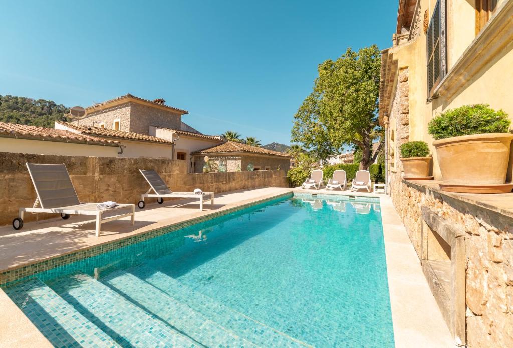 een zwembad met stoelen en een huis bij Son Apiana in Mancor del Valle