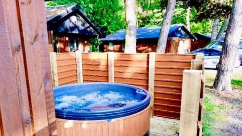 una grande vasca idromassaggio situata accanto a una recinzione di legno di Beech Lodge 4 Hot Tub a York