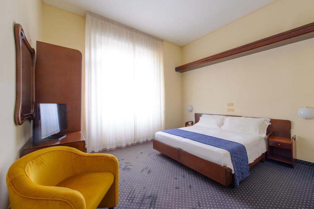 A bed or beds in a room at Palace Hotel Domus Mea Riccione