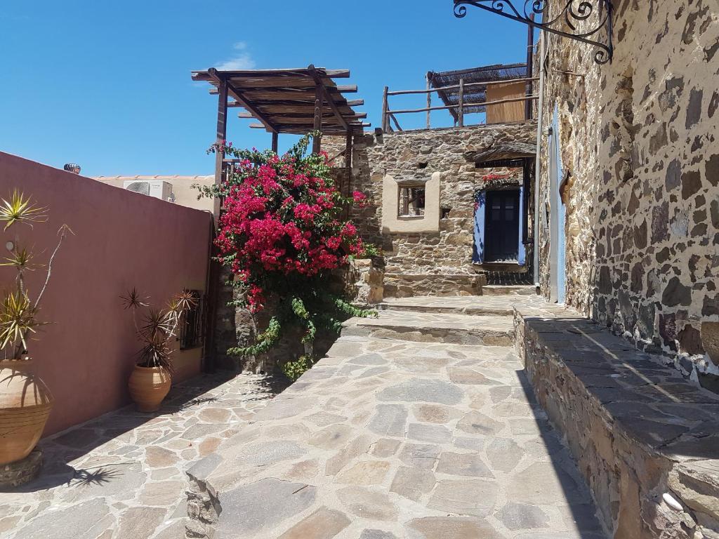 a stone walkway with flowers on the side of a building at Chios Houses, beautiful restored traditional stone houses with an astonishing seaview in Volissos