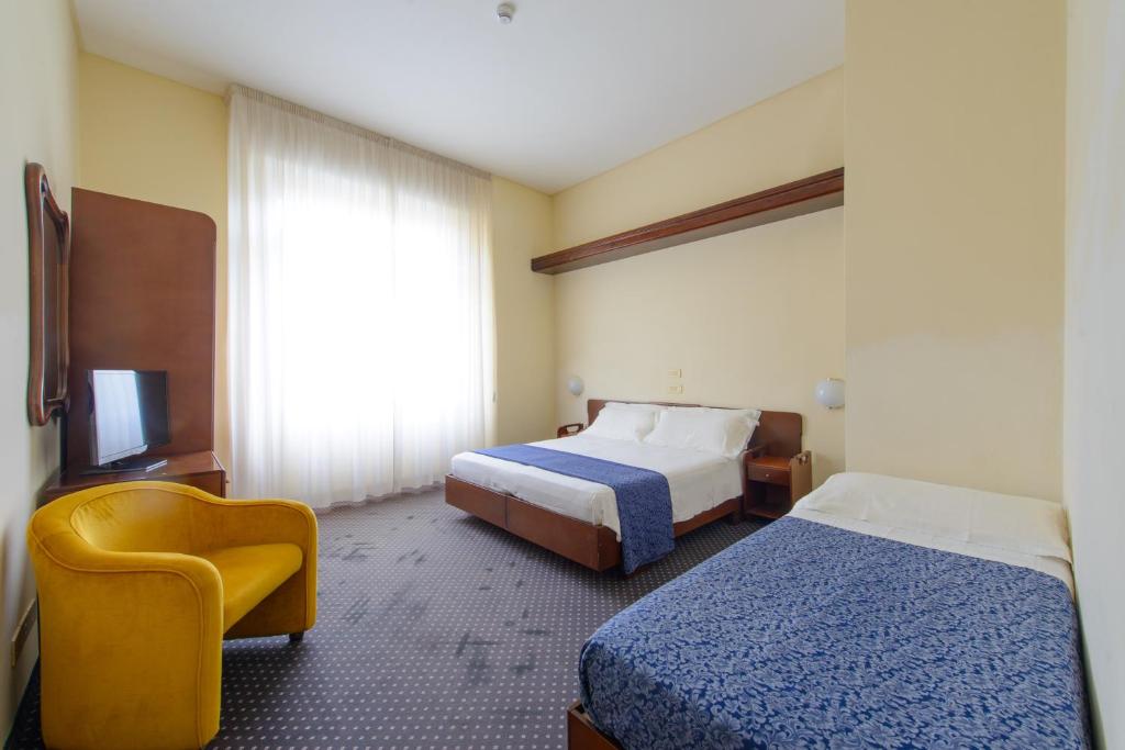 A bed or beds in a room at Palace Hotel Domus Mea Riccione