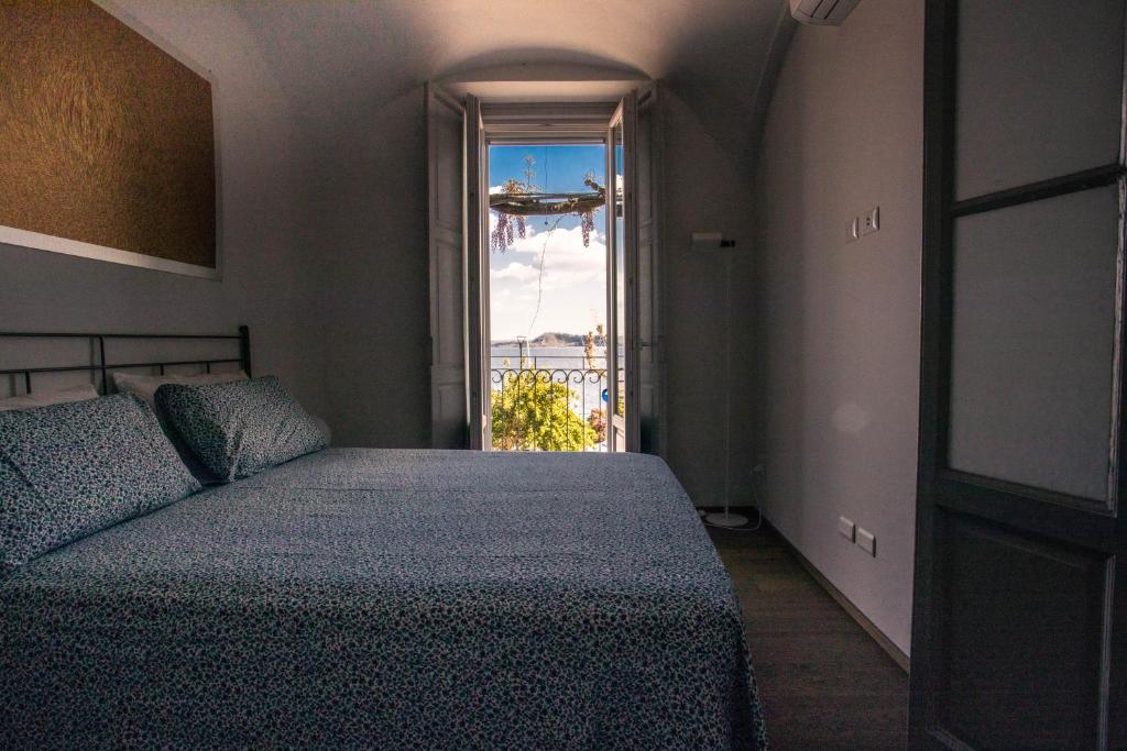 um quarto com uma cama e uma janela em La dimora del Glicine 2 em Belgirate