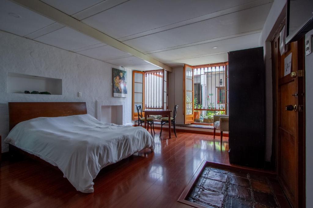 Un dormitorio con una cama y una mesa y sillas. en Apartaestudios La Candelaria, en Bogotá
