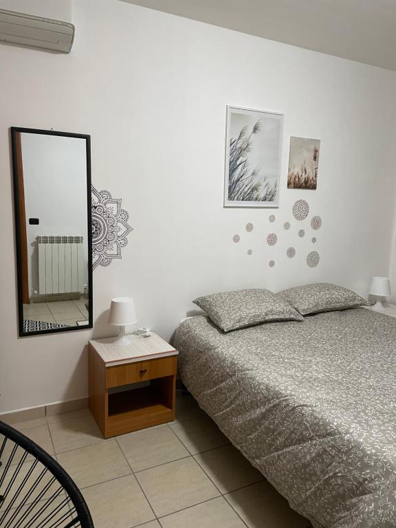 1 dormitorio con cama, espejo y mesa en La villetta 2.0, en Rende