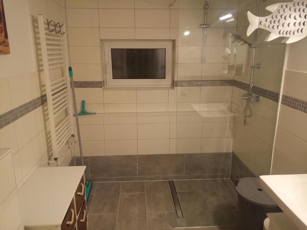 a bathroom with a shower with a window and a toilet at Ferienbungalow FeWo Eutin Süsel Sierksdorf Strand Ostsee in Süsel