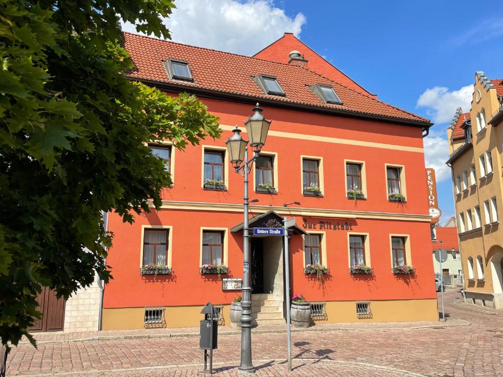 Weidaにあるzur altstadtの赤い屋根の大きなオレンジ色の建物