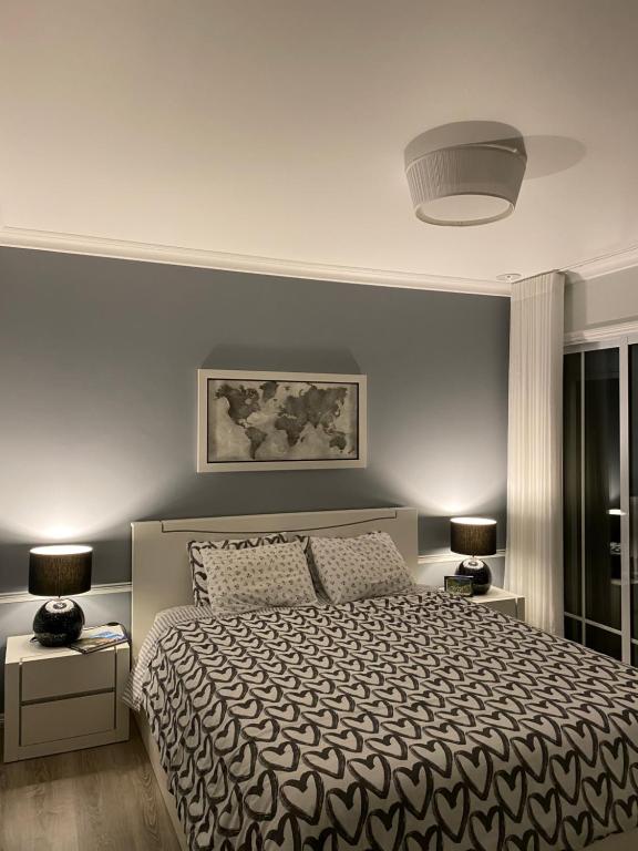a bedroom with a large bed and two lamps at Modern room (with deck) in Povoação