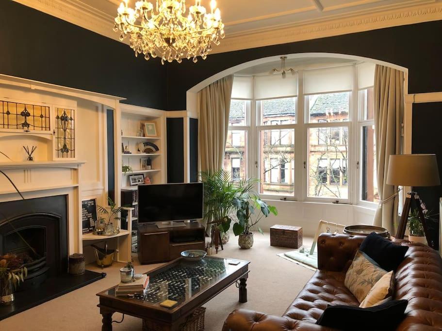 un soggiorno con divano e camino di Spacious 3 bed flat in the heart of the west end. a Glasgow