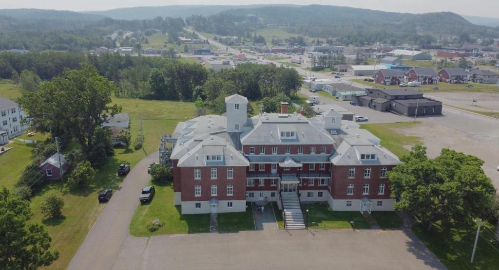 an aerial view of a large red brick building at Le Couvent in Sainte-Anne-des-Monts
