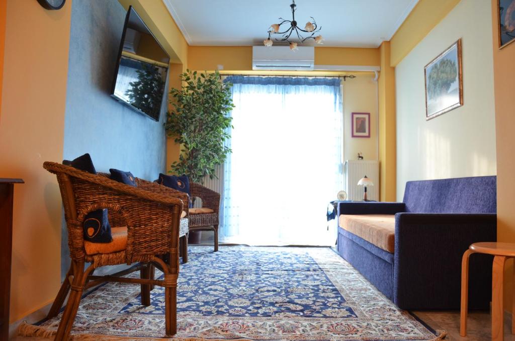 sala de estar con sofá y ventana en Sunray luxury apartment Volos, en Volos