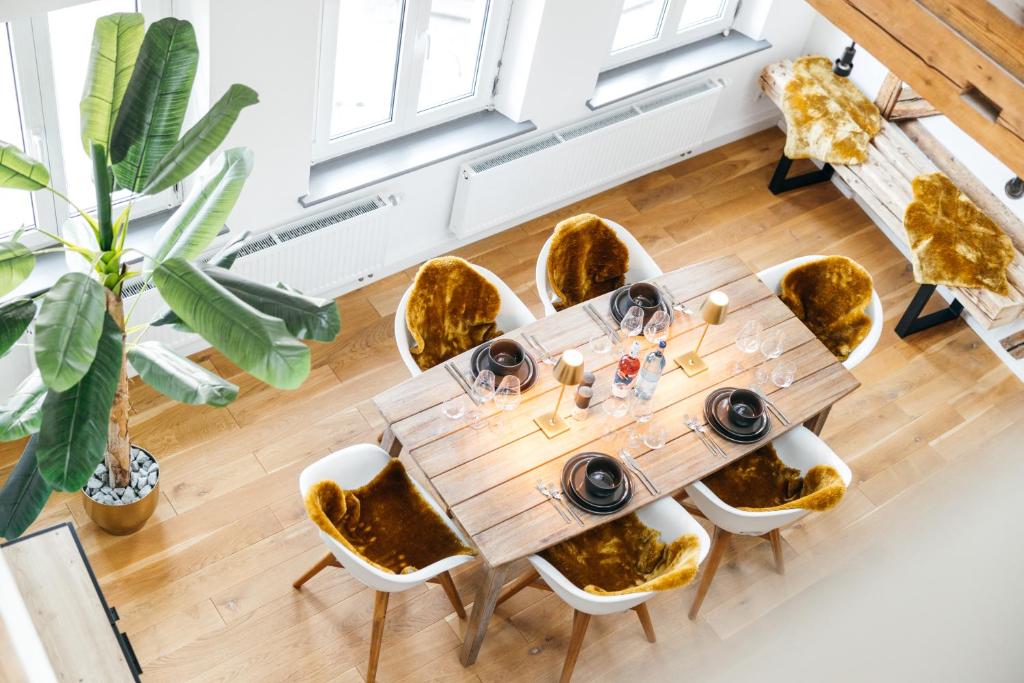 a dining room with a wooden table and chairs at HEIMATEL - Luxury Penthouse Loft in Ravensburg