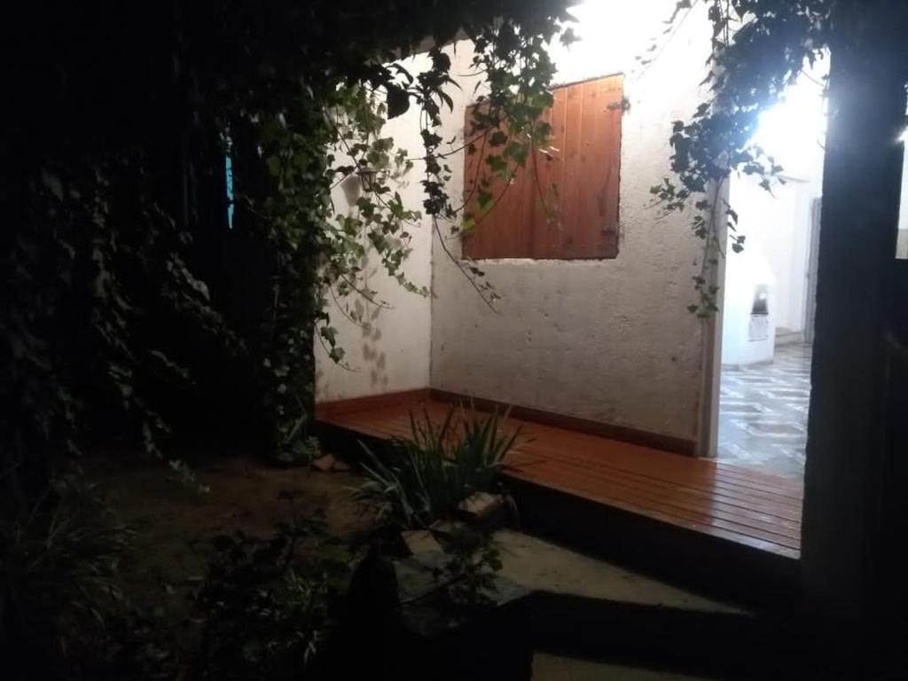 een huis met een houten veranda en een houten deur bij El jazmín in Villa Santa Cruz del Lago
