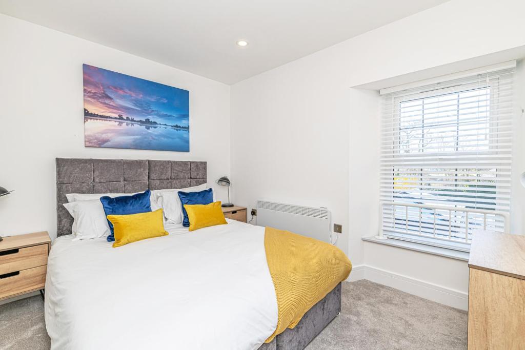 a bedroom with a large bed with yellow and blue pillows at Eden Grove Holiday Retreat in Kirkby Thore