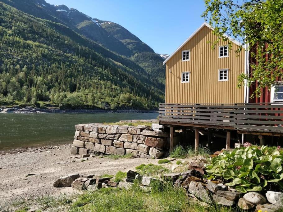 ein Haus auf einem Dock neben einem Fluss in der Unterkunft Sjøgata Riverside Rental and Salmon Fishing in Mosjøen