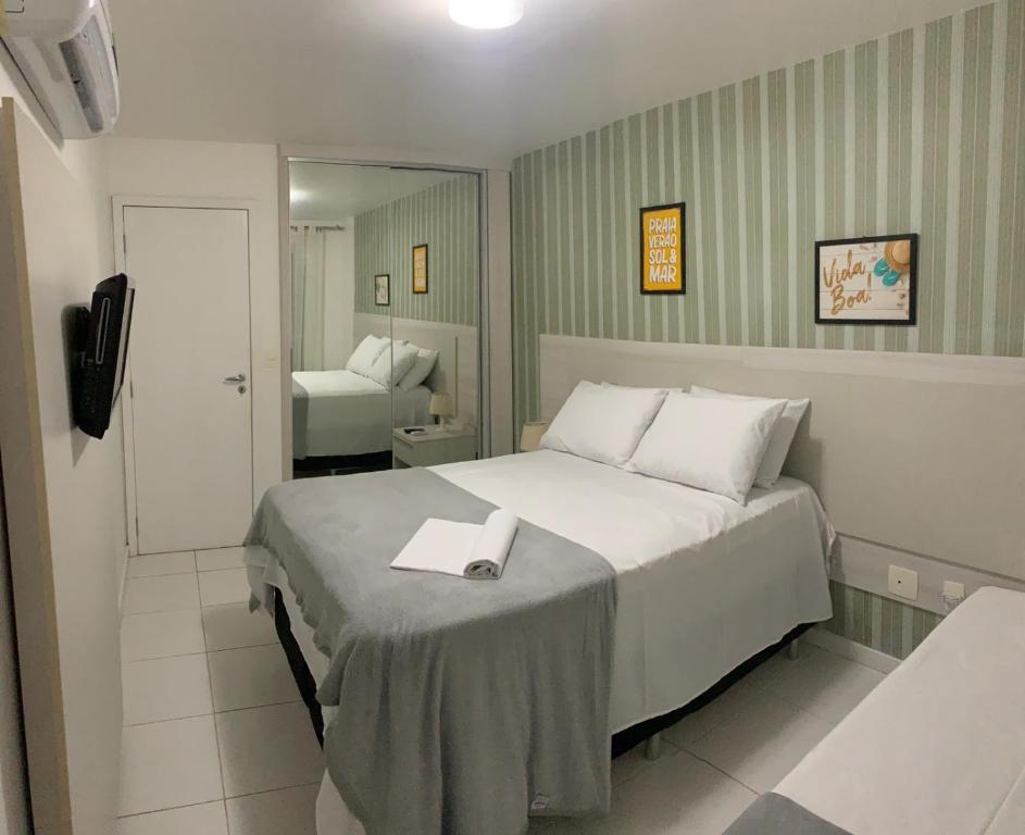 een slaapkamer met een bed met een boek erop bij MANDAI Apartamento Cabo Frio in Cabo Frio