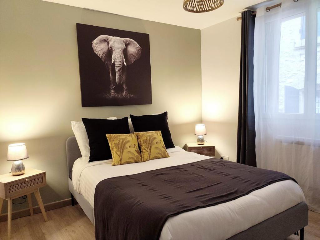 una camera con un letto e una foto di un elefante di Entre Uzès et le Pont du Gard le Cocon de SOPHIA à deux pas des Gorges du Gardon a Collias