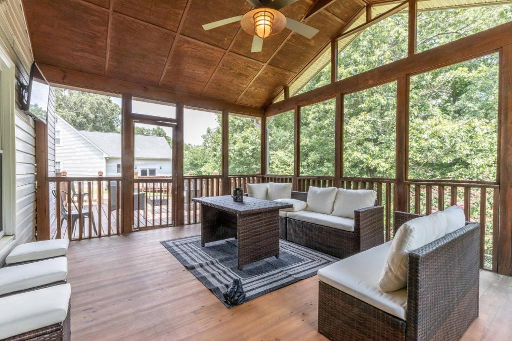 a screened in porch with furniture and a ceiling fan at Memories by the Lake in Gainesville