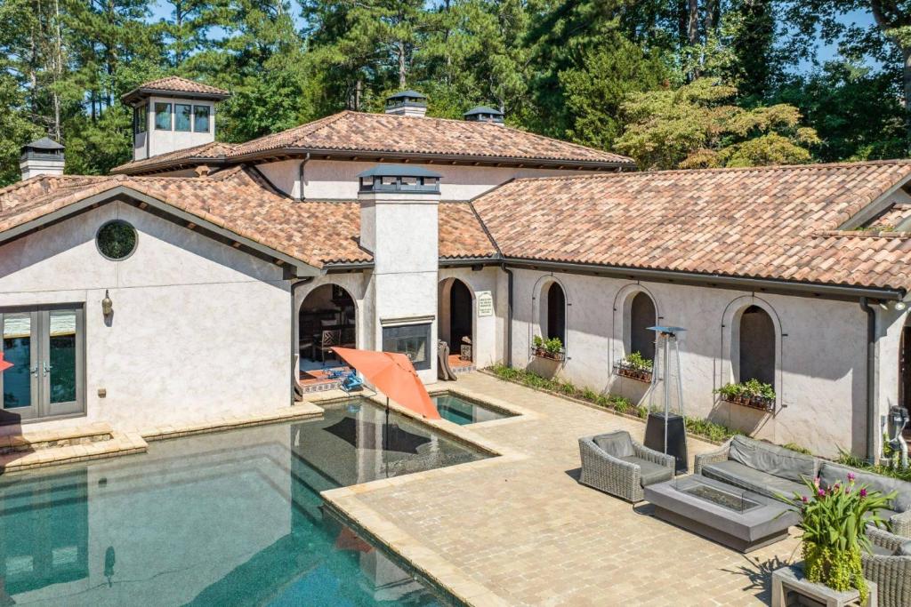 a home with a swimming pool and a house at Villa Flora in Marietta