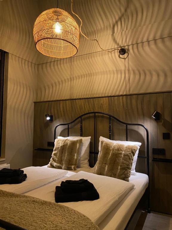 1 dormitorio con 2 camas y lámpara de araña en Huusje18, en Nunspeet