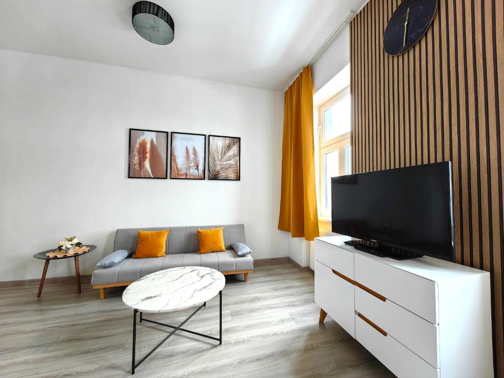 ein Wohnzimmer mit einem Sofa und einem Flachbild-TV in der Unterkunft Adonis Apartment in Wien