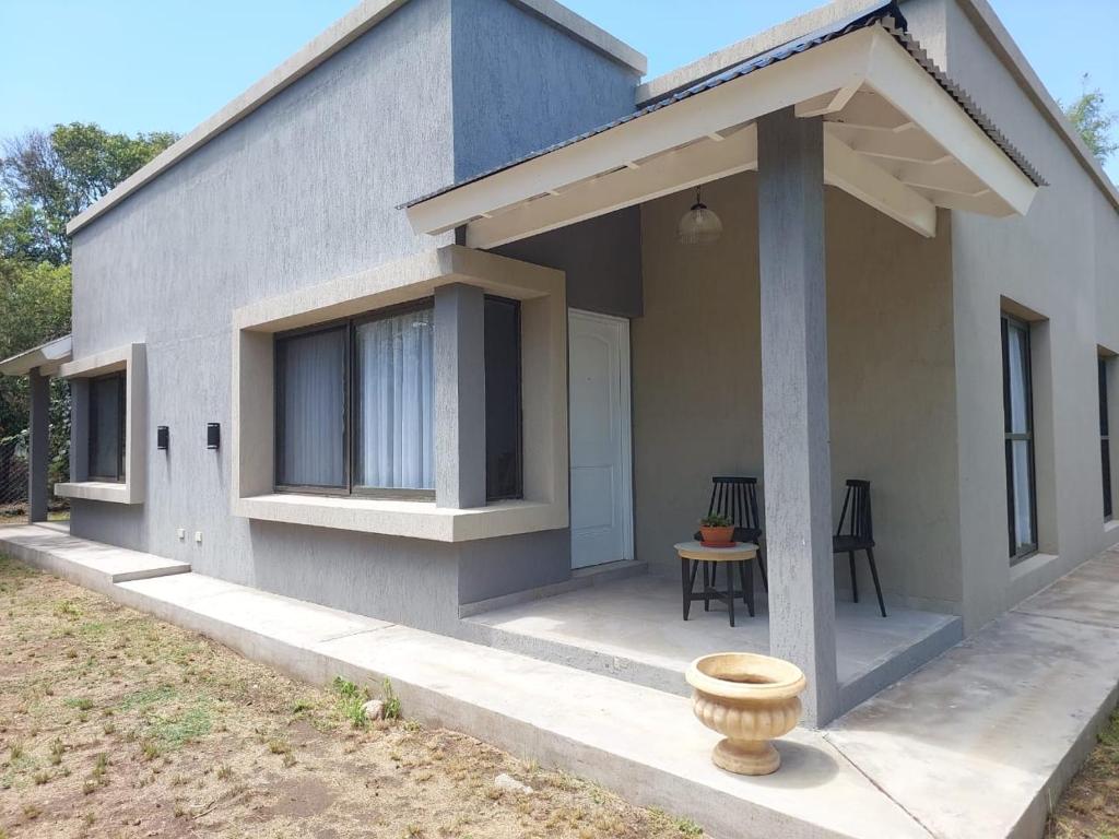 una casa con un porche y una mesa frente a ella en •JADE• Casas de alquiler en Los Molles