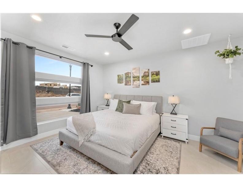 a bedroom with a bed and a chair and a window at Desert Hideaway in Hurricane