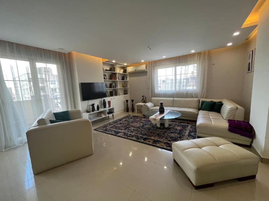 Unique apartment in Almaza في القاهرة: غرفة معيشة كبيرة مع أريكة وطاولة