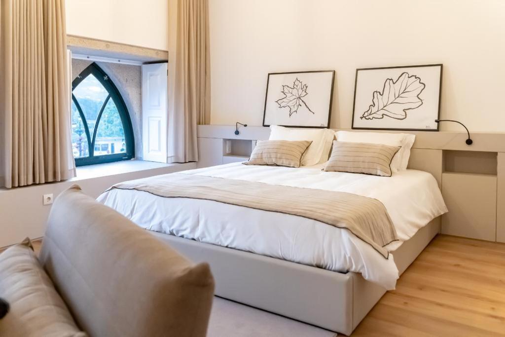 1 dormitorio con 1 cama grande y 1 sofá en Camões Apartments, en Ponte de Lima