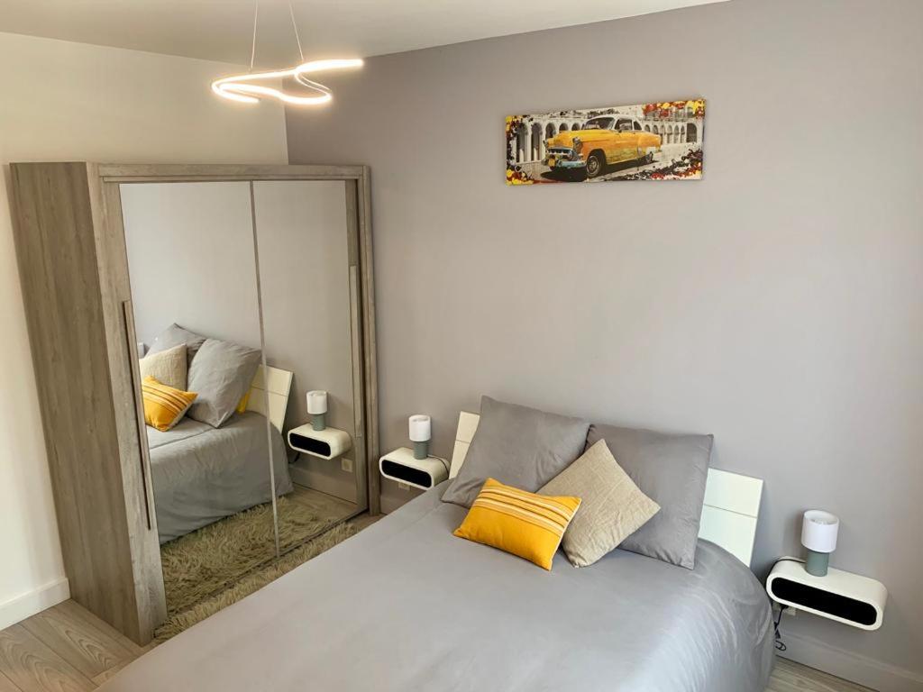 1 dormitorio con cama y espejo grande en Foras Urban Living à 2 pas du festival, en Cannes