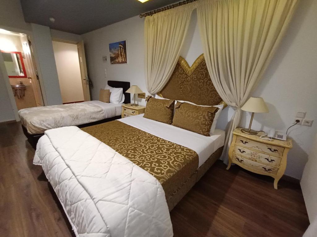 um quarto de hotel com duas camas e uma janela em Queens Leriotis Hotel em Pireu