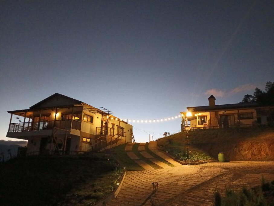 un bâtiment sur une colline avec des lumières allumées dans l'établissement La Casita de Charo 1, à Constanza