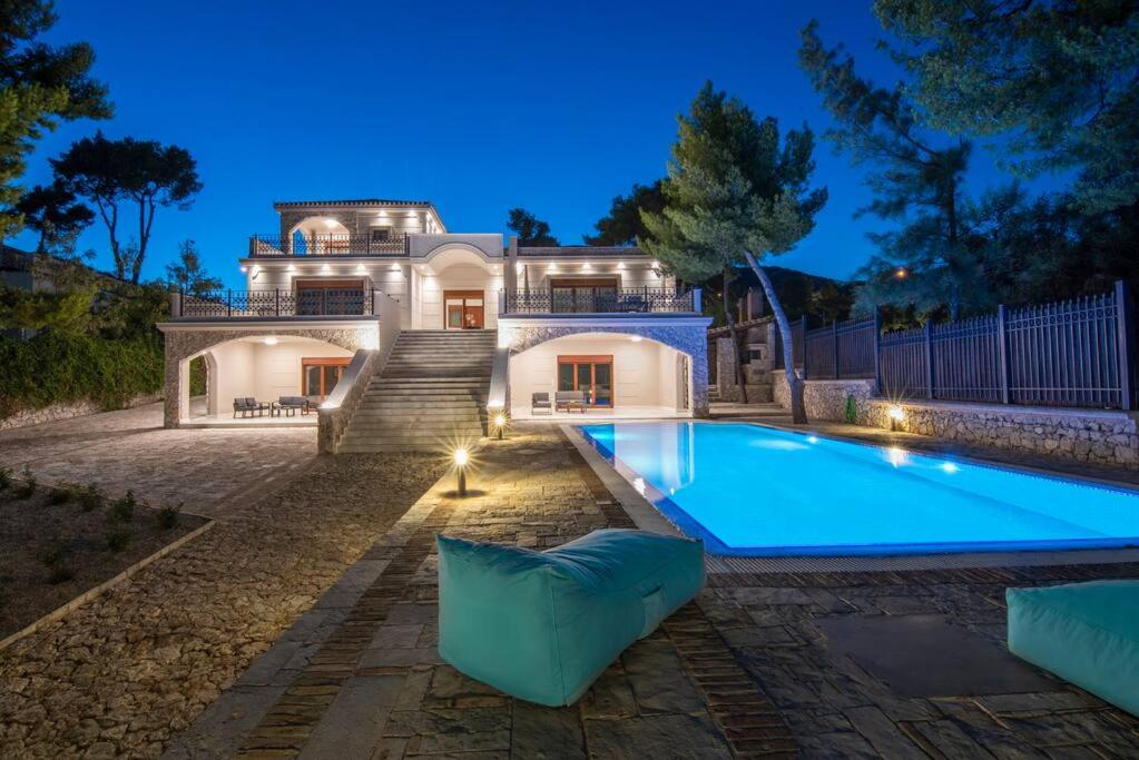 een groot huis met een zwembad ervoor bij villa lion in Agioi Theodoroi