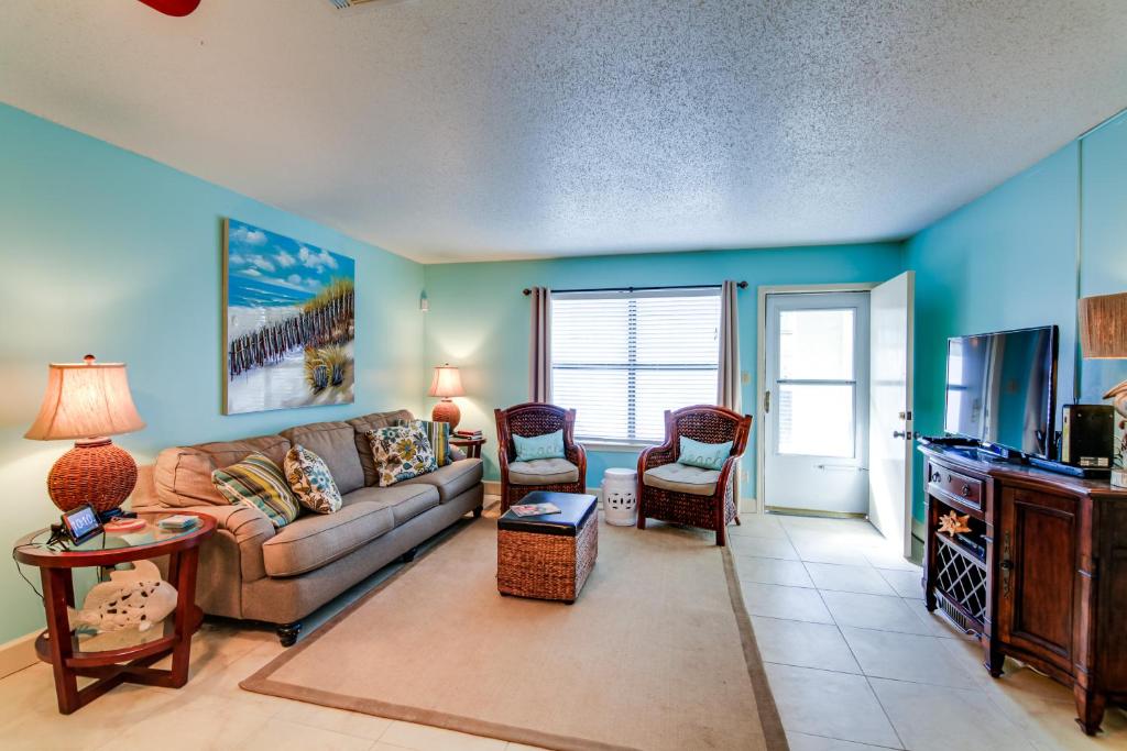 ein Wohnzimmer mit einem Sofa und einem Tisch in der Unterkunft Destin Townhome with Balcony - Walk to the Beach! in Destin