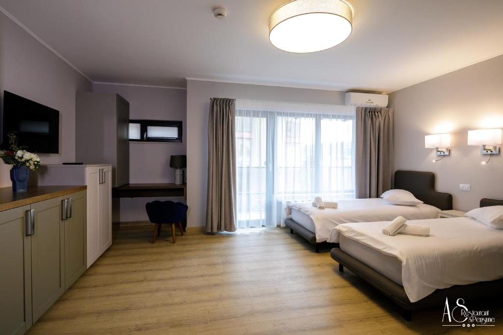 Habitación de hotel con 2 camas y ventana en Pensiunea AS, en Floreşti