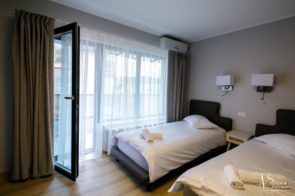 Habitación de hotel con 2 camas y espejo en Pensiunea AS, en Floreşti