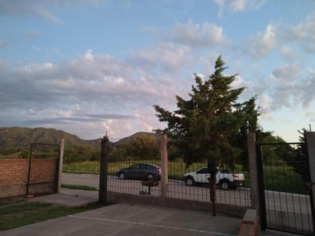 einen Zaun mit einem Baum vor einem Auto in der Unterkunft La Trinidad San Luis, La Punta in La Punta