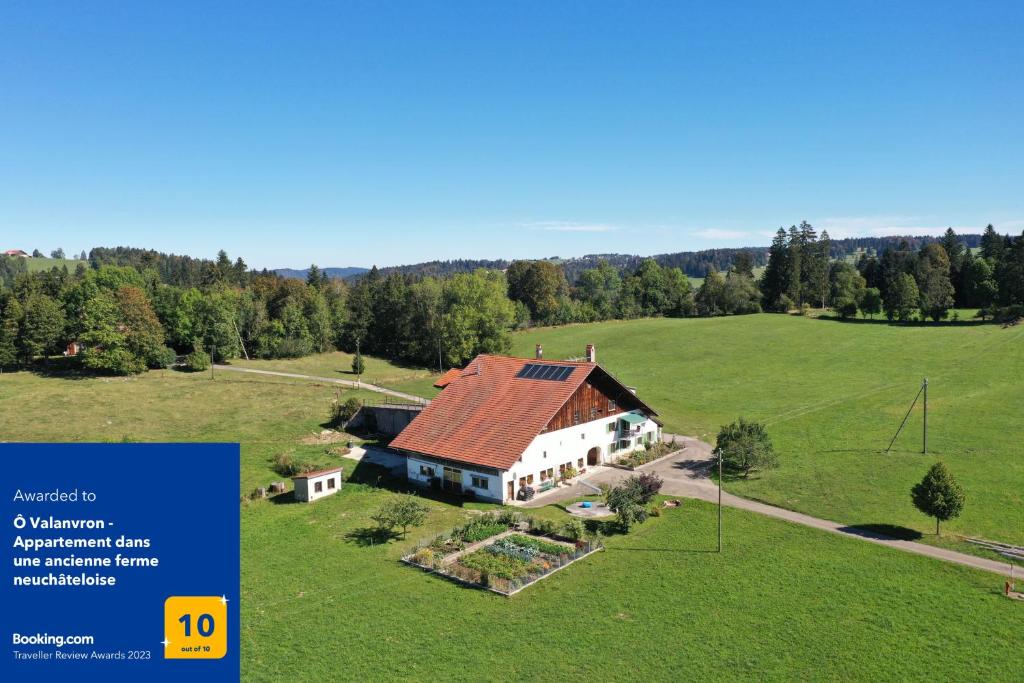 eine Luftansicht eines Hauses auf einem Feld in der Unterkunft Ô Valanvron - Appartement dans une ancienne ferme neuchâteloise in La Chaux-de-Fonds