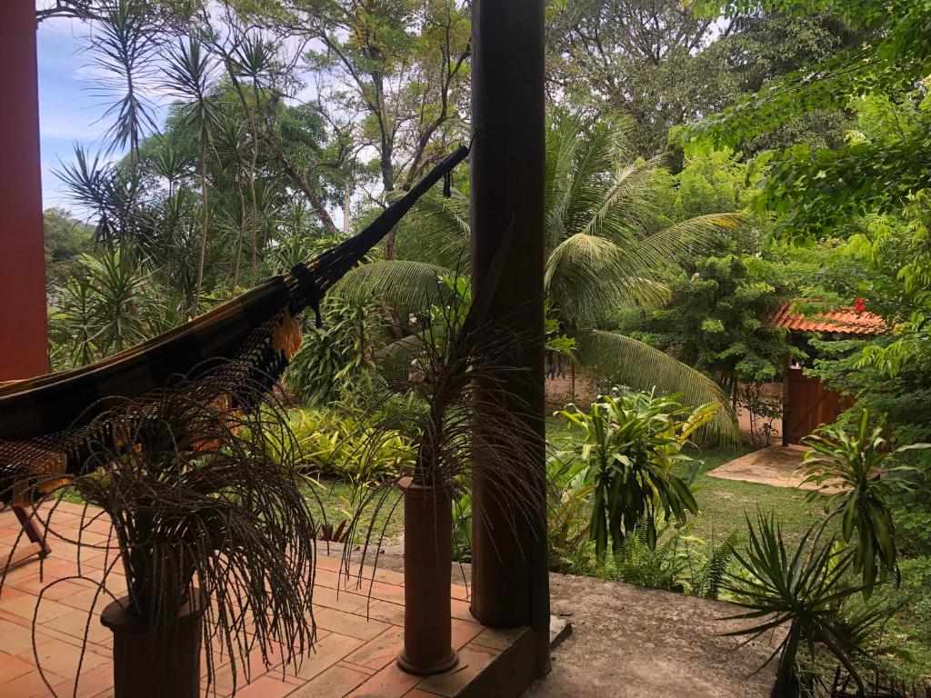 una hamaca en un jardín con árboles y plantas en Vila Enayá, en Itacaré