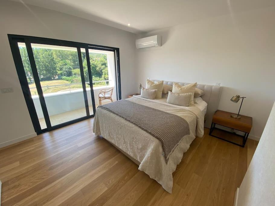 um quarto com uma cama e uma janela grande em Luxury Home - Vila Golfe Amarante em Amarante