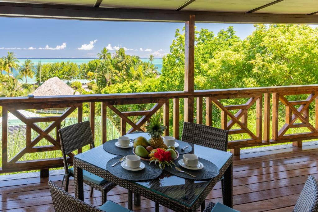 uma mesa num deque com vista para o oceano em FARE ATEA em Bora Bora