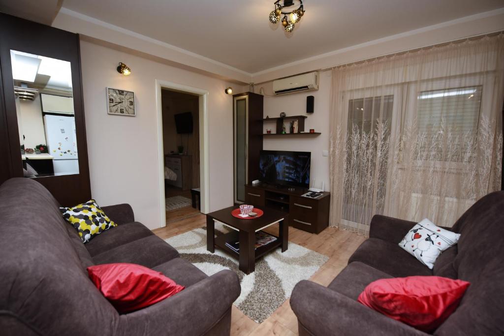 een woonkamer met 2 banken en een televisie bij Memento in Kragujevac