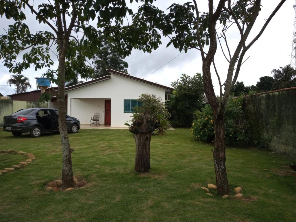 沙帕達－杜斯吉馬朗伊斯的住宿－Singela Casa em Chapada dos Guimarães，两棵树的院子中,有一辆汽车